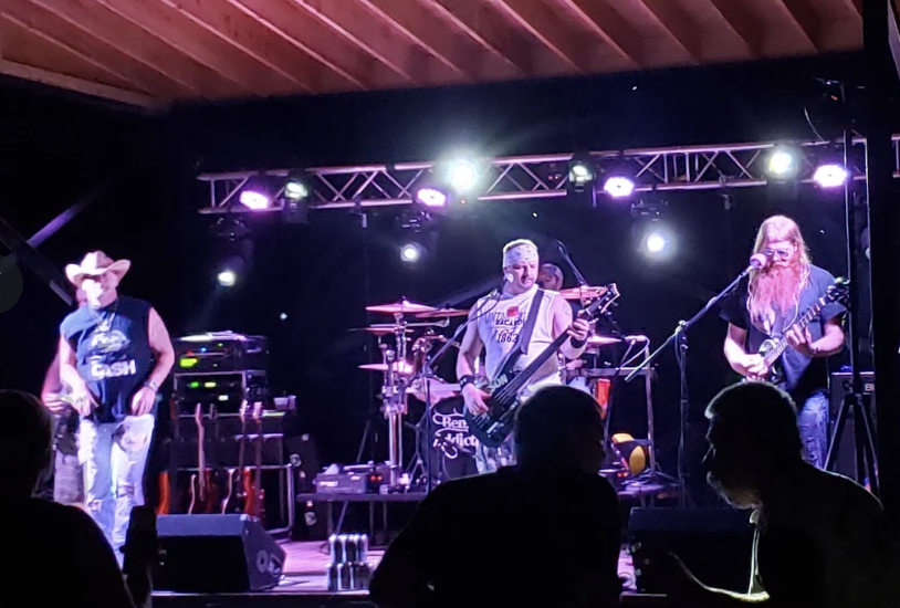 Band playing on the covered stage under stage lights